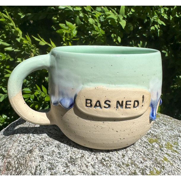 Grus i mingrn og mrkebl lbeglasur og teksten "Bas ned"