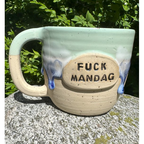 Mintgrøn kop med lilla løbeglasur og teksten "fuck mandag!