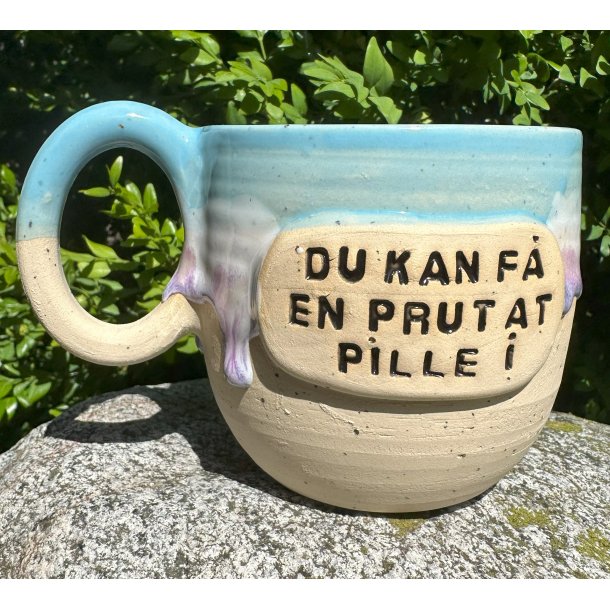 Lysebl kop med lilla lbeglasur og teksten "du kan f en prut at pille I"