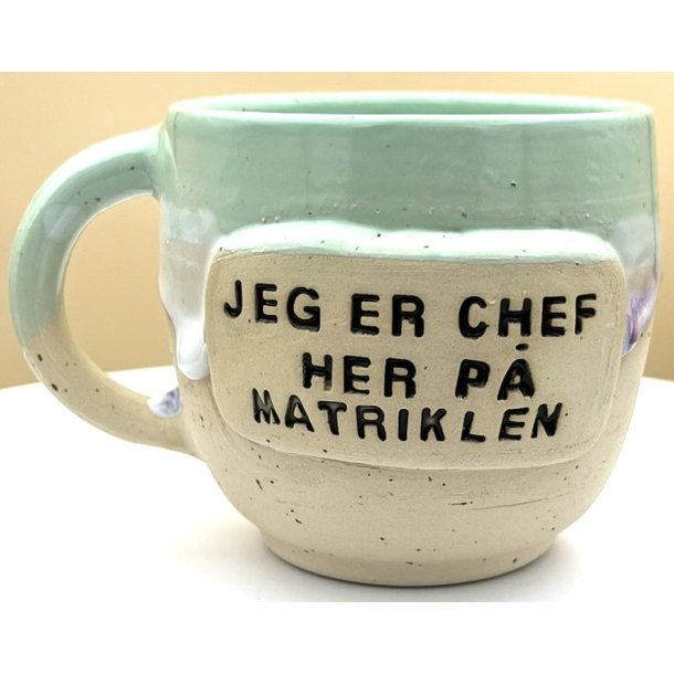 Keramik krus m/hank og citat-tekst "Jeg er chef her p� matriklen"