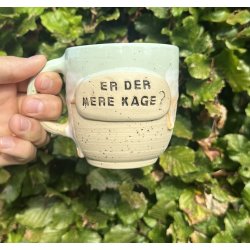 Keramik krus m/hank og citat-tekst "Er der mere kage ?"