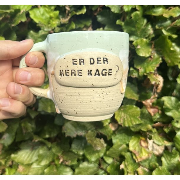 Keramik krus m/hank og citat-tekst "Er der mere kage ?"