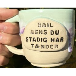 Keramik krus m/hank og citat-tekst "Smil mens du stadig har tnder"