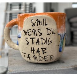 Keramik krus m/hank og citat-tekst "Smil mens du stadig har t�nder"
